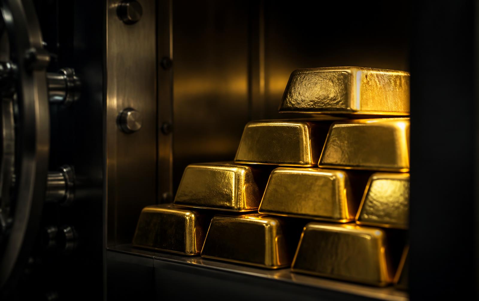 Gold bullion bars stacked inside a steel vault